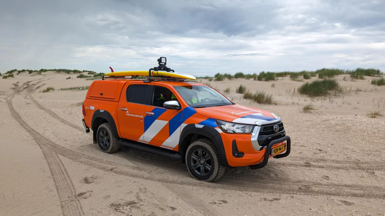 Reddingsbrigade‑voertuig op het strand, voorzien van opvallende striping, flitsers en zwaailampen, ingericht door Marelko.